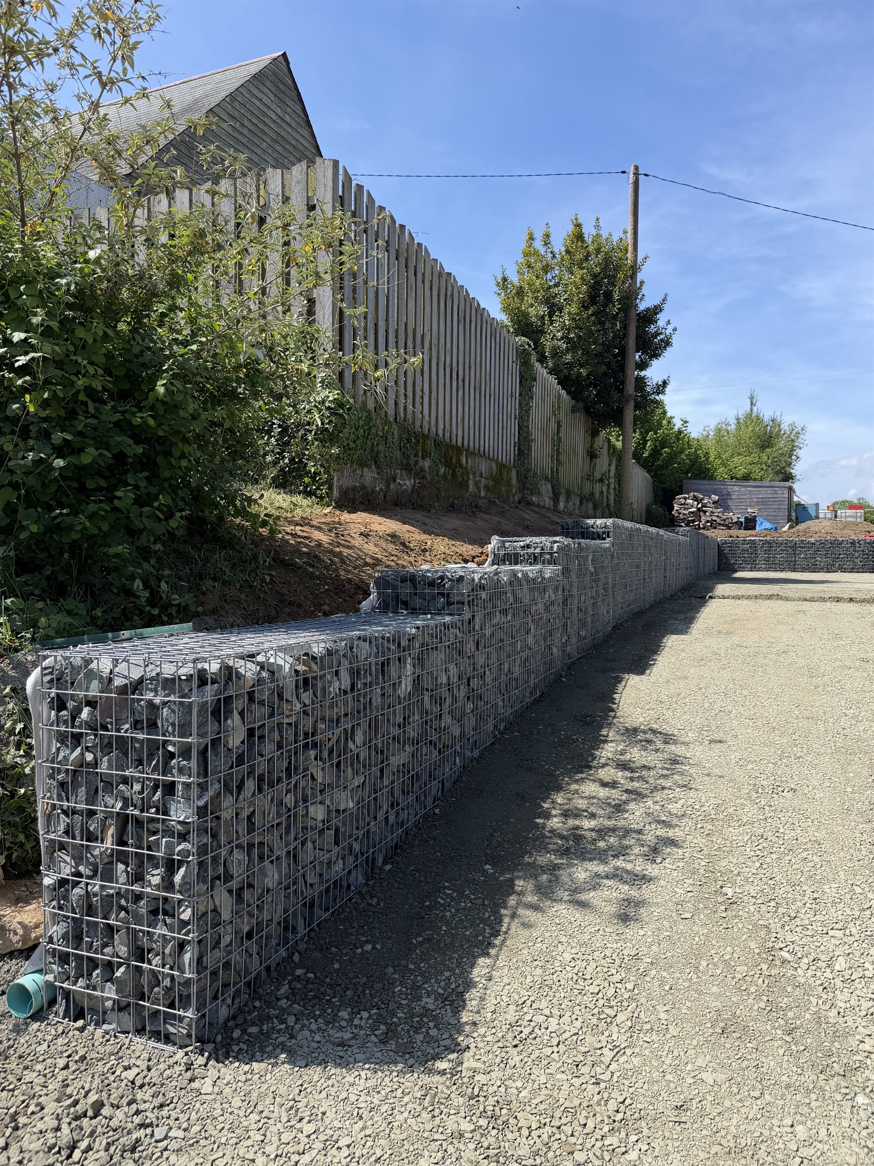 Mur de gabions en pierres empilées le long d'une allée gravillonnée