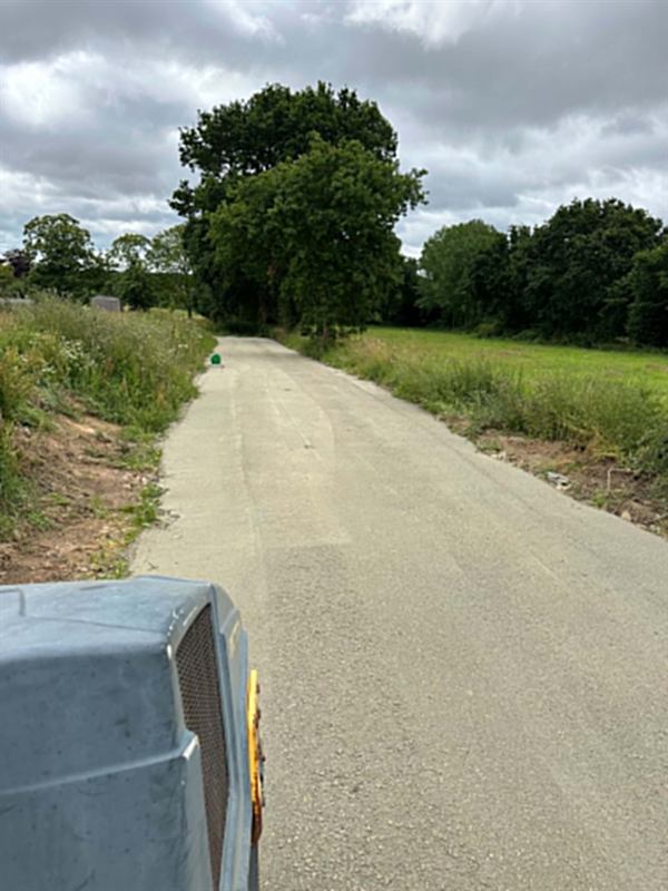 Chemin de campagne empierré et compacté entre deux prairies