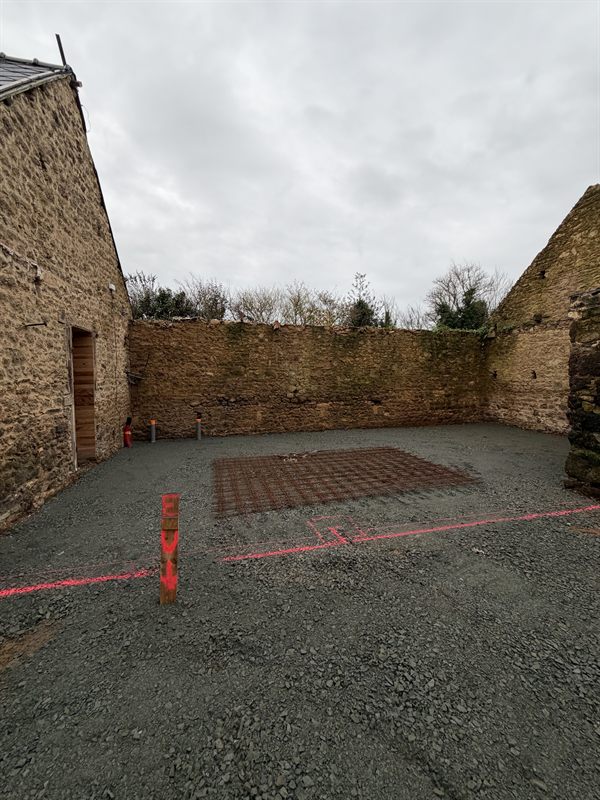 Cour dégagée en pierre concassée avec treillis soudé et traçage au sol