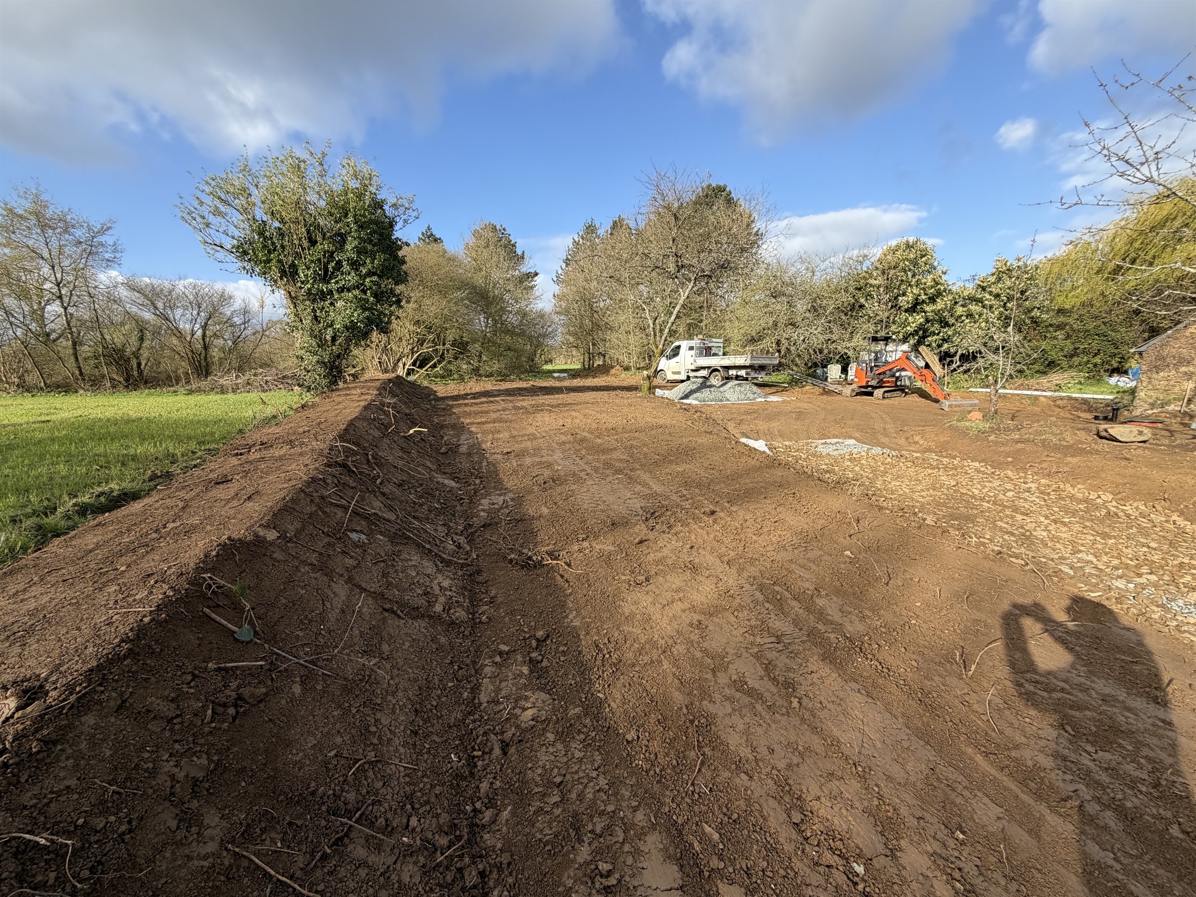 Plateforme de terre terrassée, camion benne et pelle sur le chantier